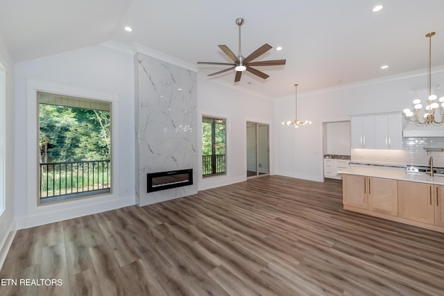 kitchen featuring decorative light fixtures, ornamental molding, a premium fireplace, decorative backsplash, and white cabinets