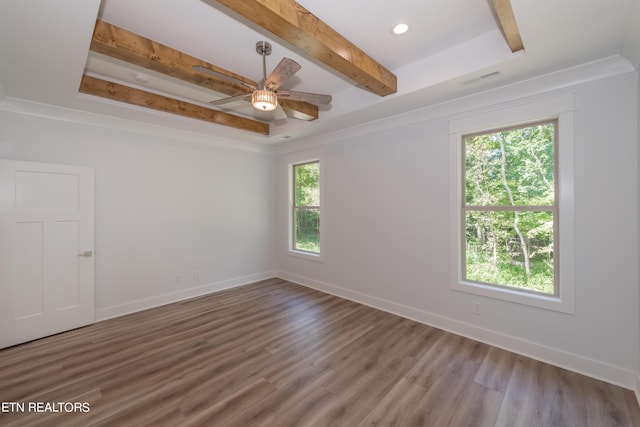 unfurnished room with a healthy amount of sunlight, wood-type flooring, and beamed ceiling