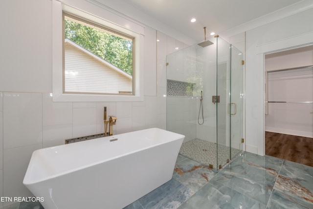 bathroom featuring separate shower and tub and tile walls