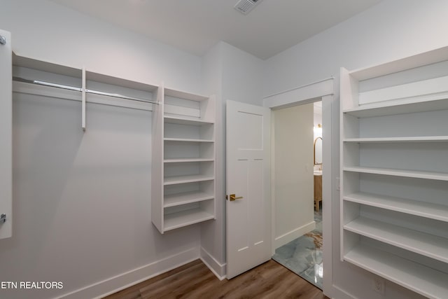 spacious closet with dark wood-type flooring