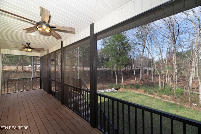 wooden terrace with ceiling fan, a yard, and a sunroom