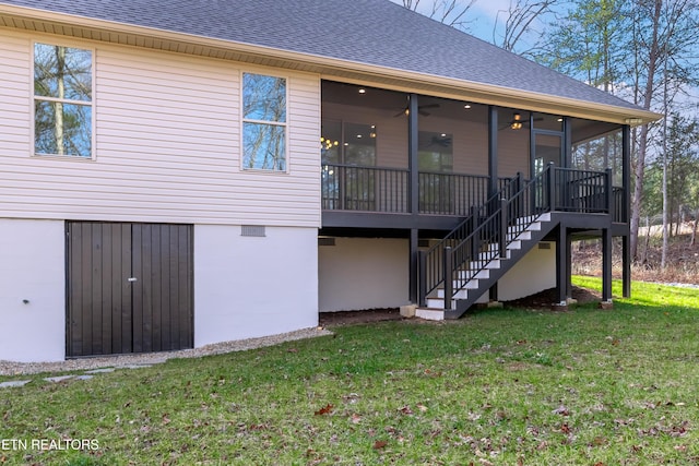 rear view of property featuring a yard, a sunroom, and ceiling fan