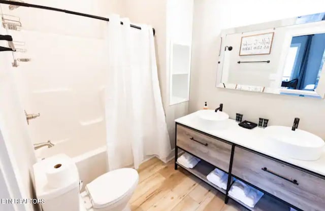 full bathroom with toilet, shower / bath combination with curtain, vanity, and hardwood / wood-style flooring