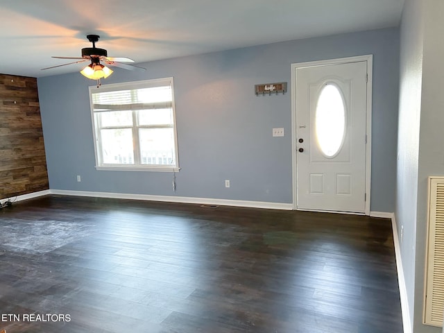 entrance foyer featuring ceiling fan, wooden walls, and dark hardwood / wood-style flooring