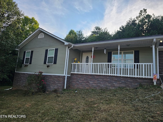 ranch-style house featuring a porch and a front lawn