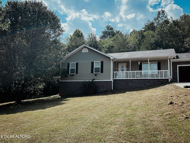 ranch-style home with covered porch, a garage, and a front yard