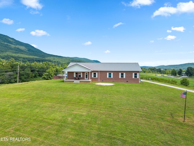 single story home with a mountain view and a front lawn