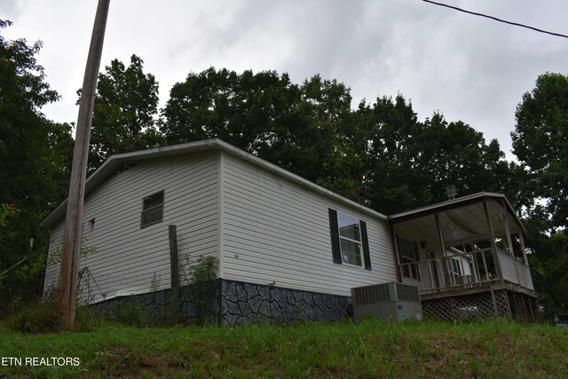 view of property exterior with central air condition unit and a deck