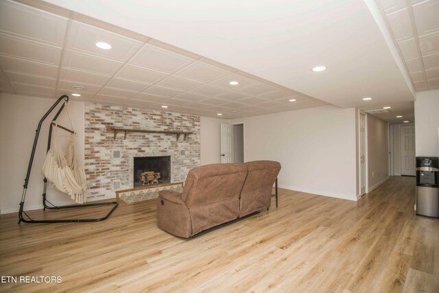 living room with light hardwood / wood-style floors and a brick fireplace