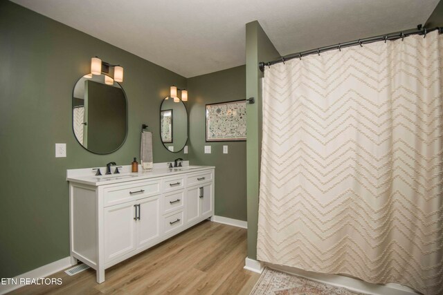 bathroom featuring a shower with shower curtain, vanity, and wood-type flooring