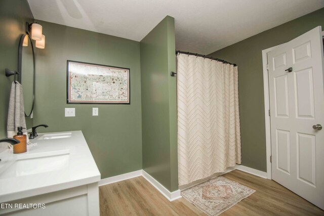 bathroom with a shower with shower curtain, vanity, and wood-type flooring