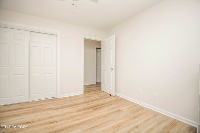 unfurnished bedroom with ceiling fan, a closet, and light hardwood / wood-style floors