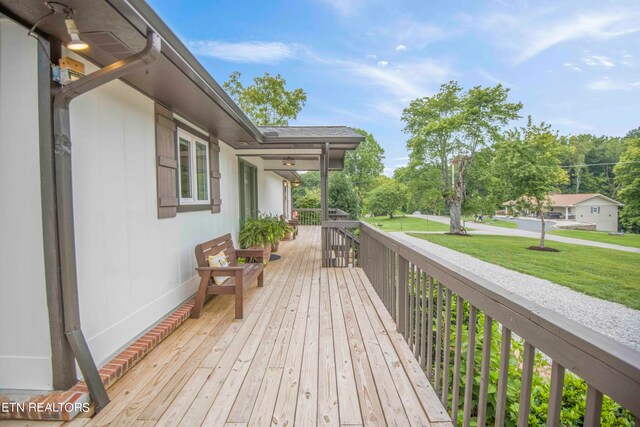 wooden terrace featuring a yard