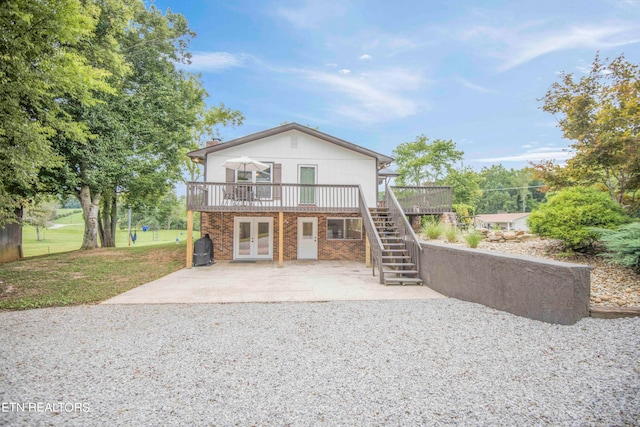 rear view of house with french doors and a lawn