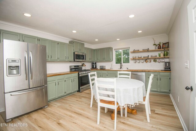 kitchen featuring decorative backsplash, light hardwood / wood-style flooring, wood counters, green cabinetry, and appliances with stainless steel finishes