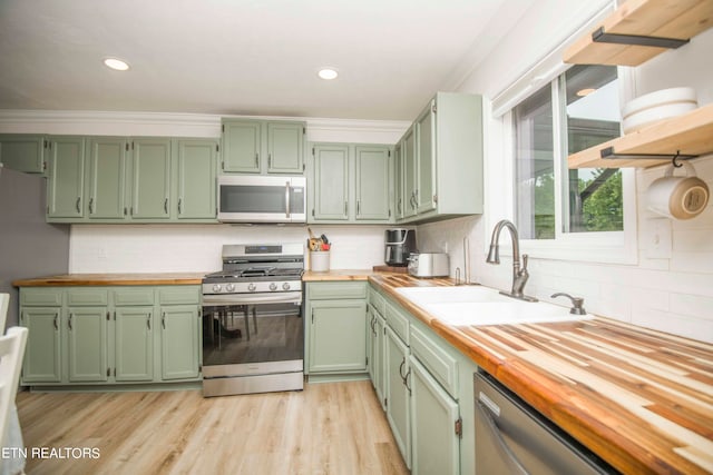 kitchen featuring decorative backsplash, wooden counters, appliances with stainless steel finishes, and light hardwood / wood-style floors