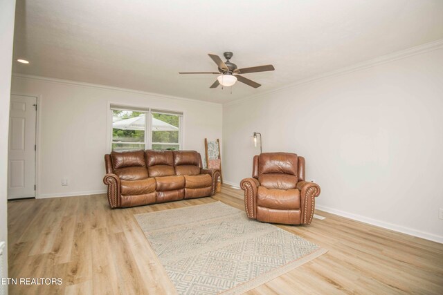 living room with ceiling fan, crown molding, and light hardwood / wood-style flooring