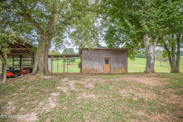 view of yard with a carport and an outbuilding