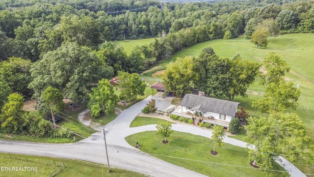 birds eye view of property featuring a view of trees