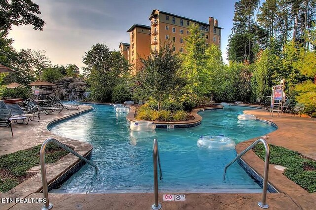 pool at dusk with a patio