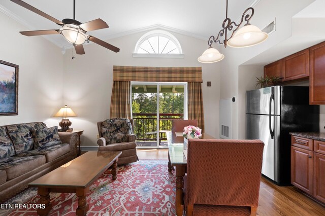 living room with ceiling fan, wood-type flooring, high vaulted ceiling, and ornamental molding