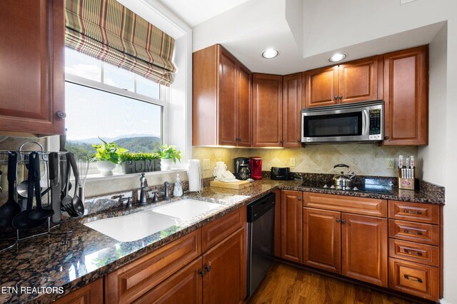 kitchen featuring decorative backsplash, stainless steel appliances, dark hardwood / wood-style flooring, and dark stone counters