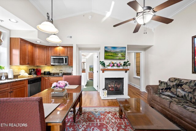 kitchen featuring crown molding, appliances with stainless steel finishes, ceiling fan, tasteful backsplash, and light hardwood / wood-style flooring