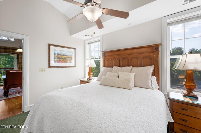 bedroom with ceiling fan, wood-type flooring, and multiple windows