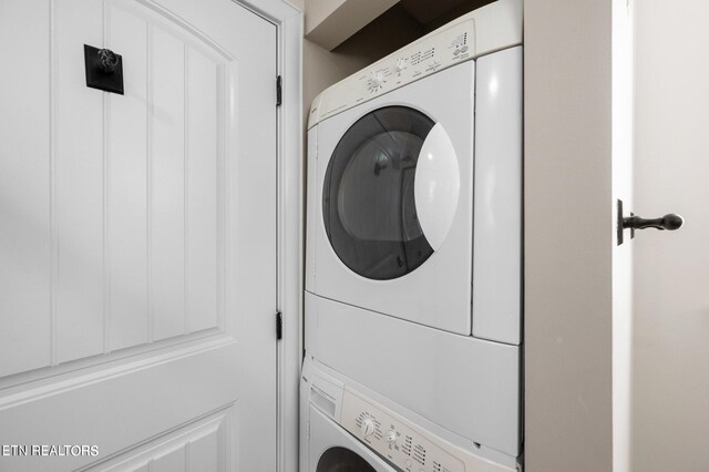 clothes washing area with stacked washer / dryer