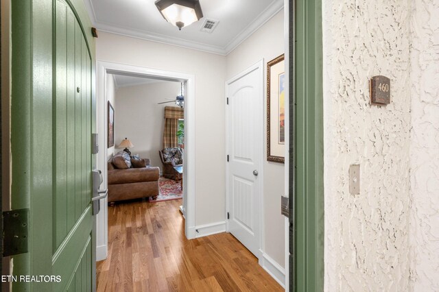 hall featuring light hardwood / wood-style flooring and crown molding