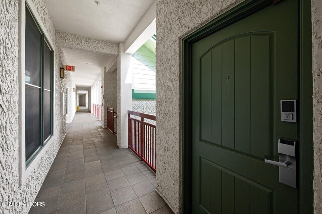 corridor featuring tile patterned floors and a textured ceiling