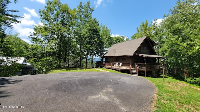 view of property exterior with a lawn and a wooden deck