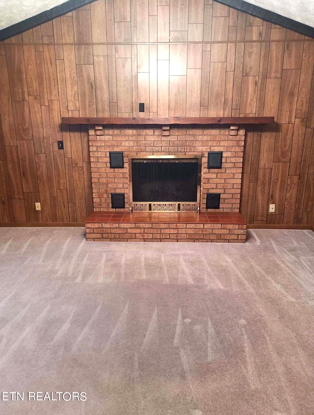 interior details with wood walls, carpet floors, and a brick fireplace