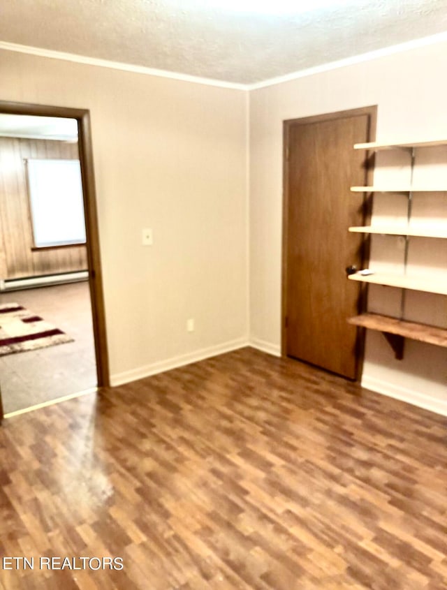 interior space featuring a baseboard heating unit, wood-type flooring, and a textured ceiling