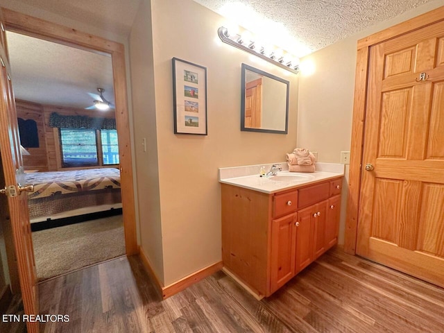 bathroom with wood-type flooring, a textured ceiling, and vanity