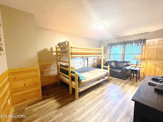 bedroom with hardwood / wood-style flooring and a textured ceiling