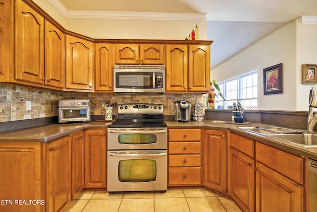 kitchen with light tile patterned flooring, appliances with stainless steel finishes, sink, and backsplash