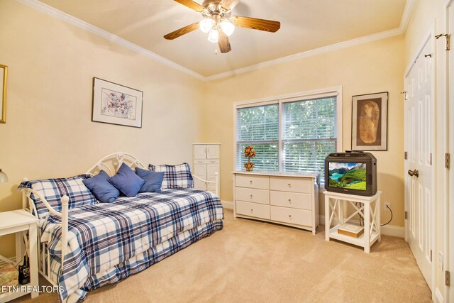 bedroom with light carpet, crown molding, a closet, and ceiling fan