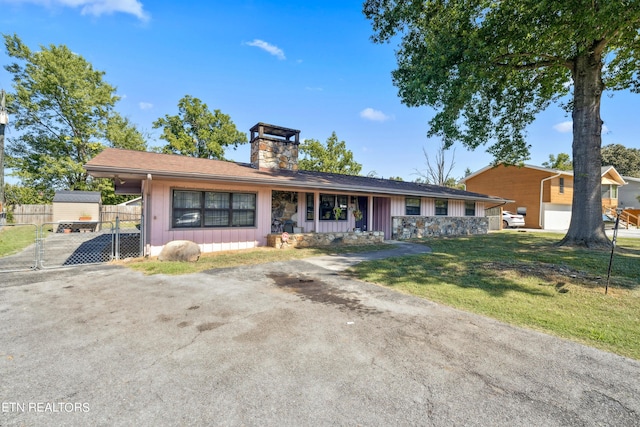 single story home featuring a front lawn, a gate, fence, board and batten siding, and a chimney