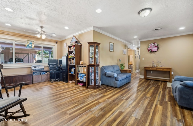 living room featuring a textured ceiling, ceiling fan, crown molding, and wood-type flooring