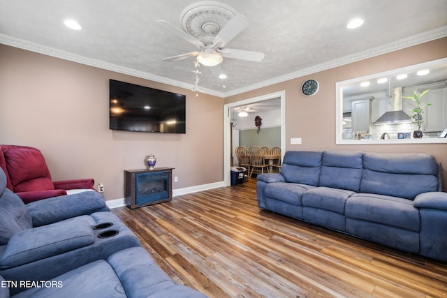 living room featuring ceiling fan, light wood-type flooring, and ornamental molding