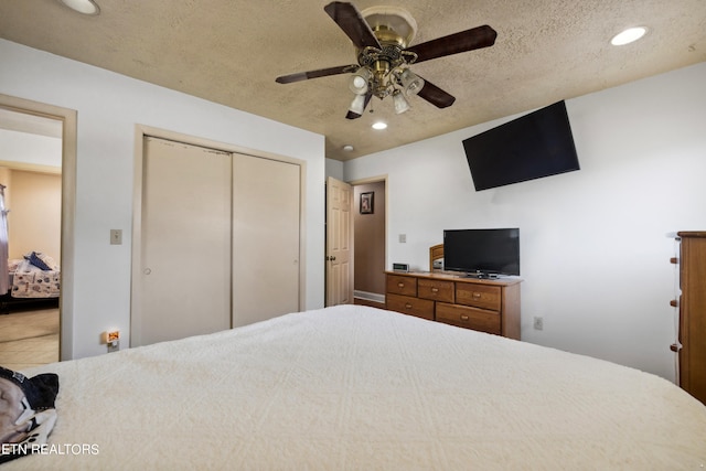 bedroom featuring ceiling fan, a closet, a textured ceiling, and tile patterned flooring