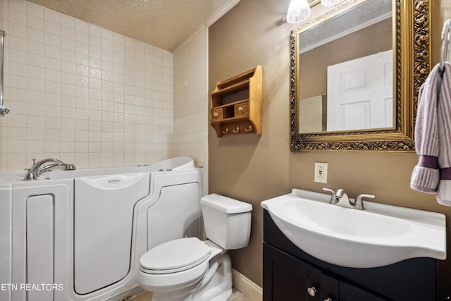 bathroom featuring a textured ceiling, toilet, and vanity