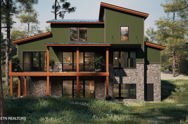 rear view of property featuring metal roof, a standing seam roof, and stone siding