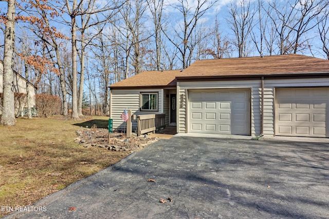 ranch-style home with a garage and a front lawn