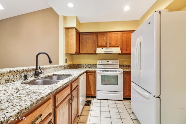 kitchen with sink, white appliances, light stone countertops, and light tile patterned floors