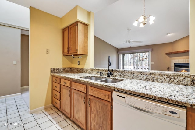 kitchen featuring light tile patterned flooring, ceiling fan with notable chandelier, dishwasher, sink, and light stone counters