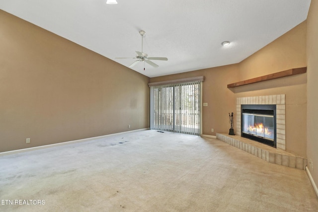 unfurnished living room with ceiling fan, carpet floors, a fireplace, and vaulted ceiling