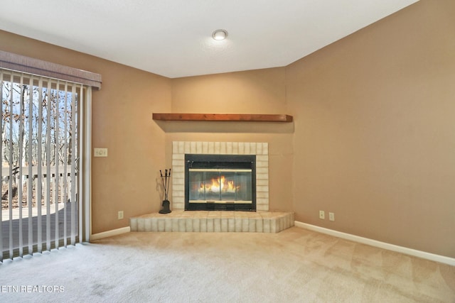 unfurnished living room with a fireplace and carpet