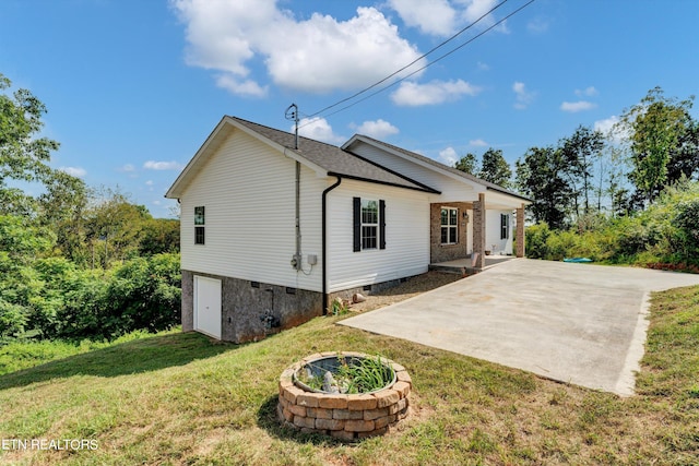 view of side of home featuring a patio area and a lawn